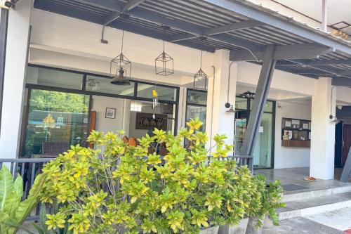 a building with potted plants in front of it at Jitrawadee Hotel in Sathani Nakhon Lampang