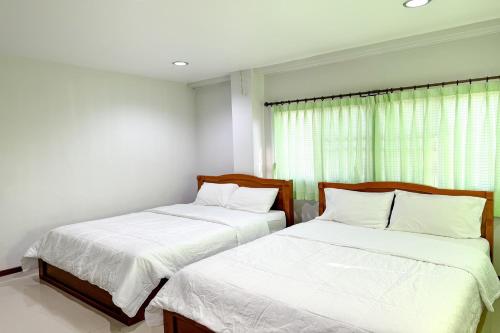 two beds sitting next to each other in a bedroom at Jitrawadee Hotel in Sathani Nakhon Lampang