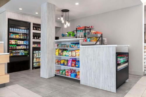 a grocery store aisle with a refrigerator and shelves of food at Hilton Garden Inn Denver Airport in Aurora