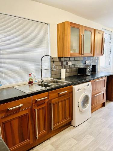 a kitchen with a sink and a washing machine at Orchard Road in Portsmouth
