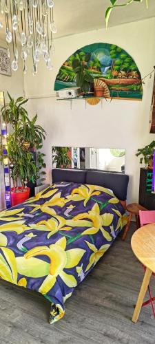 - une chambre dotée d'un lit avec une couverture bleue et jaune dans l'établissement Canopée, paisible, chaleureux, lumineux, balcon, à Paris