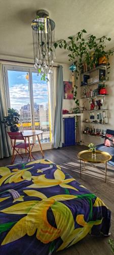un salon avec un lit et une grande fenêtre dans l'établissement Canopée, paisible, chaleureux, lumineux, balcon, à Paris