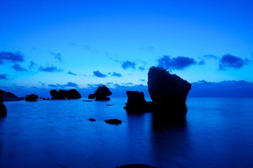 a group of rocks in the water at dusk at Hyakunagaran in Nanjo