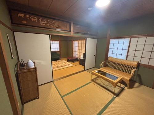 a room with a bench in the middle of a room at Koto Next Door in Otsu