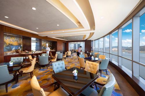 a restaurant with tables and chairs and windows at Shangri-La Wenzhou in Wenzhou