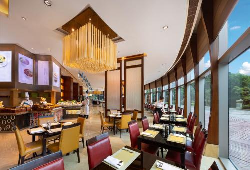 a restaurant with tables and chairs and a chandelier at Shangri-La Wenzhou in Wenzhou