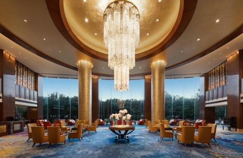 a dining room with a chandelier and tables and chairs at Shangri-La Wenzhou in Wenzhou