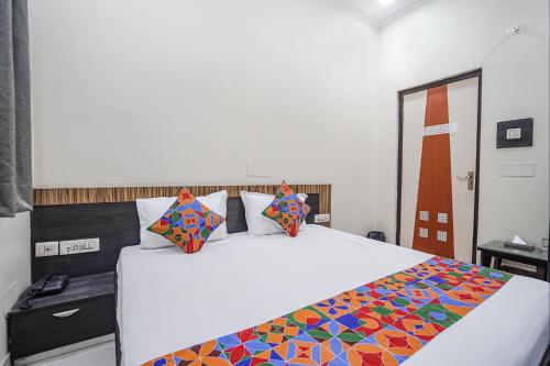 a bedroom with a large white bed with colorful pillows at FabHotel Rivlet Premium - Nr Jama Masjid and Red Fort in New Delhi