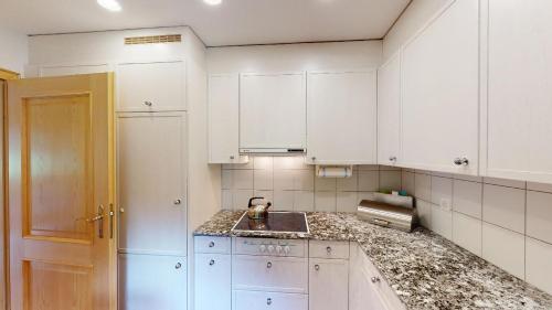 ChampferにあるApartment Trais Tschiervsの白いキッチン(白いキャビネット、シンク付)