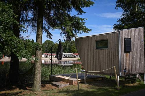 a tiny house sitting next to a lake at Sleep Space 3 - Green Tiny Spot Friesland in Schortens