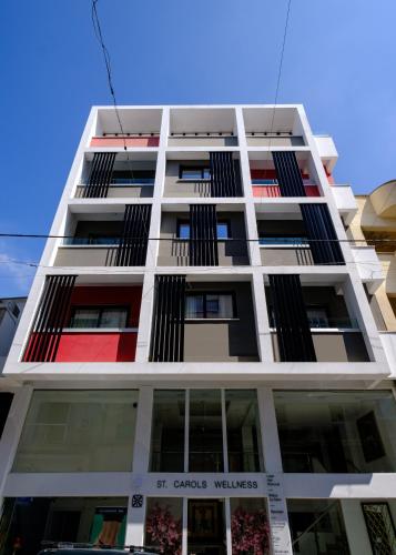 a tall white building with red and black windows at Lazuli Hermes Apartments in Larnaka