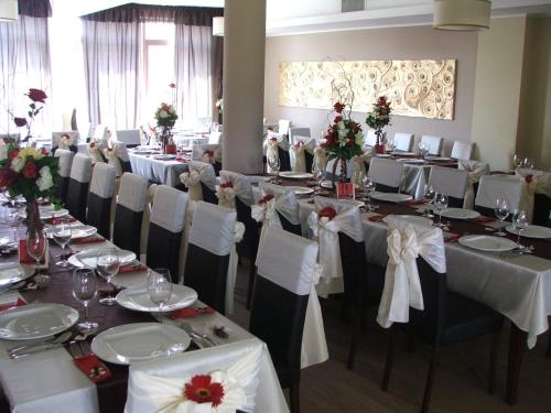 a banquet hall with tables and chairs with white tablecloths at Anthimos in Baile Felix