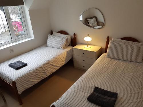 two twin beds in a room with a mirror at Bowness On Windermere, Excellent Apartment For 4 With Parking in Bowness-on-Windermere