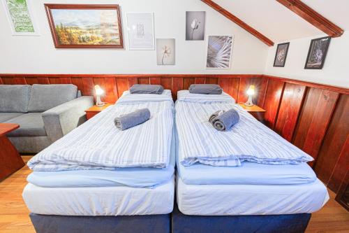 two beds in a room with a couch at Penzión Grand, Self Check-In, free private parking in Banská Bystrica