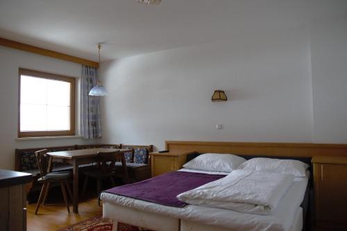 a bedroom with a bed and a dining room with a table at Appartment Danterhof in Mayrhofen