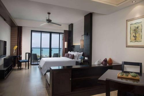 a large hotel room with a bed and a television at Ramada Plaza by Wyndham Sanya Bay in Sanya