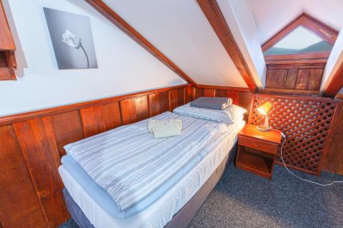 a small bedroom with a bed and a lamp at Penzión Grand, Self Check-In, free private parking in Banská Bystrica