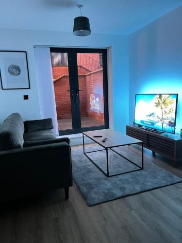 a living room with a couch and a table and a tv at Gemstone Apartments - 1BDR in Birmingham