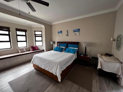 a bedroom with a large bed with blue pillows at The Lofty-Nest of Leadwood Street in Swakopmund