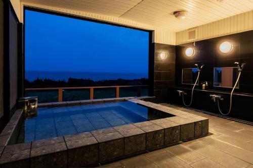 a large tub in a room with a large window at The BONDS SPAオーシャンプライベートヴィラー千葉白浜ー in Minamiboso