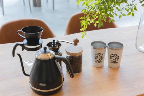 a tea kettle and two cups on a table at The BONDS SPAオーシャンプライベートヴィラー千葉白浜ー in Minamiboso