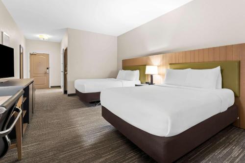 a hotel room with two beds and a flat screen tv at Country Inn & Suites by Radisson, Macon North, GA in Macon