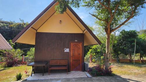 a small hut with a bench and a wooden door at Bansuanphuhong Resort in Chiang Khan