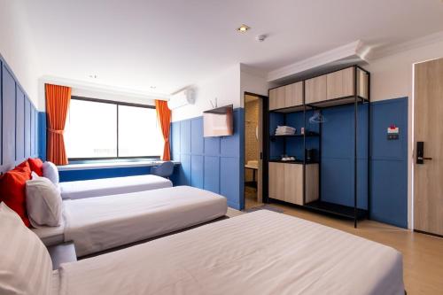 a bedroom with two beds and a blue wall at Penpark Place in Bangkok