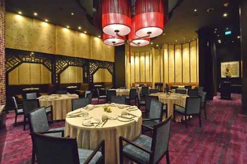 a dining room with tables and chairs and a chandelier at City of Dreams - Nobu Hotel Manila in Manila