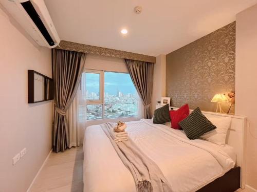 a bedroom with a large white bed and a window at 1BR Walk 1min to BTS 3min Mall Tapra WiFi 500MB in Bangkok