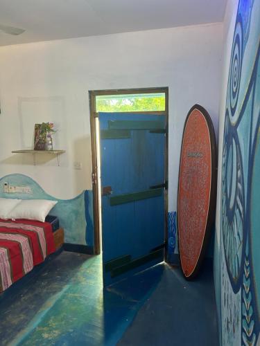 a room with a door and a surfboard on the wall at STARFISH beach bungalow in Arugam Bay