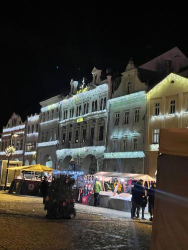 a market in front of a building at night at Hotel Zlatý Anděl in Žatec