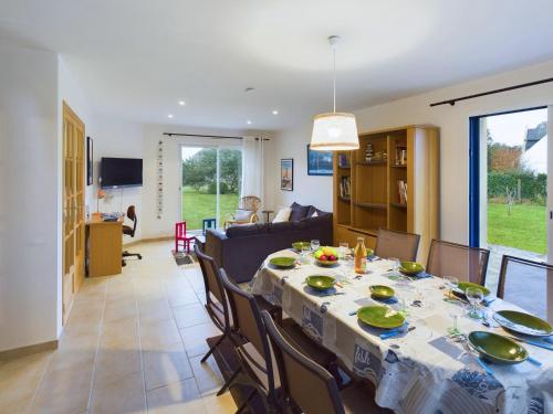 une salle à manger et un salon avec une table et des chaises dans l'établissement Penmarch Kerity, maison pour 9 avec jardin, à Penmarcʼh