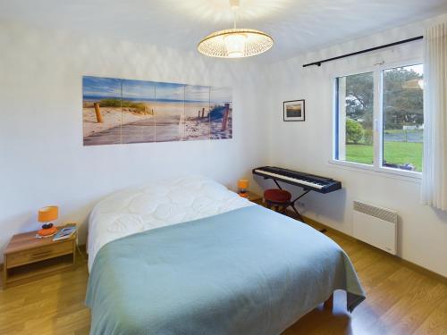 - une chambre avec un lit et un clavier à côté d'une fenêtre dans l'établissement Penmarch Kerity, maison pour 9 avec jardin, à Penmarcʼh