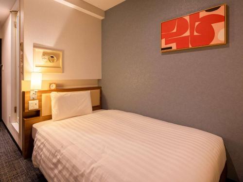 a bedroom with a white bed in a room at Comfort Inn Nagoya Sakae in Nagoya