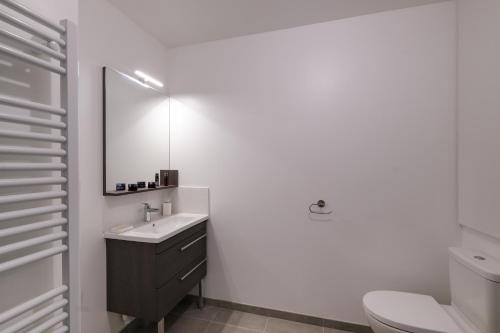 une salle de bain avec un lavabo et un miroir dans l'établissement L'Escapade pornicaise - Joli appt à Pornic, à Pornic