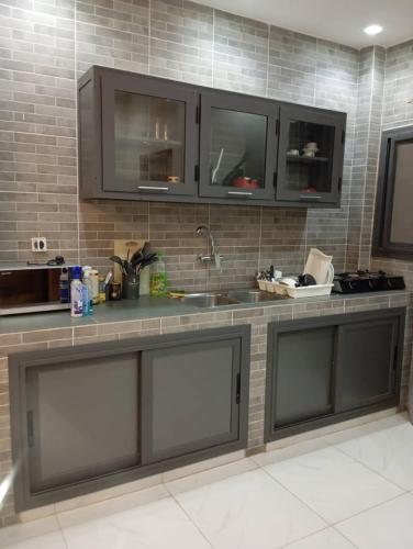 a kitchen with gray cabinets and a counter top at Almadies 2 - Studio moderne tout confort - 200m du Rd Point Sedima in Rufisque