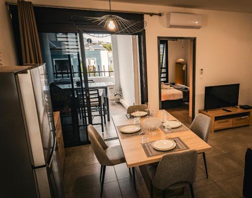 a dining room with a table and chairs and a television at Leu Burgot 1 - 3 étoiles - T2 - Front de mer & centre ville - Appt 13 in Saint-Leu