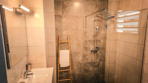 a bathroom with a shower with a ladder next to a sink at Leu Burgot 1 - 3 étoiles - T2 - Front de mer & centre ville - Appt 13 in Saint-Leu