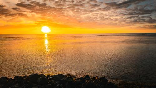 a sunset over the ocean with the sun setting at Leu Burgot 1 - 3 étoiles - T2 - Front de mer & centre ville - Appt 13 in Saint-Leu