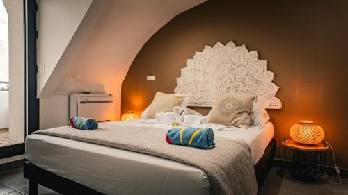 a bed with two pillows on it in a room at Leu Burgot 2 - 3 étoiles - T3 - Front de mer & centre ville - Appt 17 in Saint-Leu