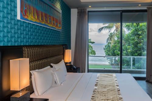a bedroom with a large bed with a view of the ocean at Golden Pearl Tangalle Beach in Tangalle