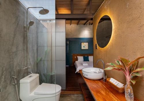 a bathroom with a sink and a toilet and a bed at AN Village 1 in Vung Tau