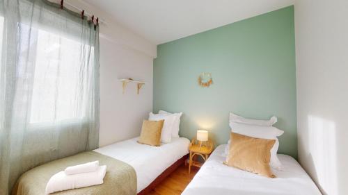 deux lits jumeaux dans une chambre avec fenêtre dans l'établissement Chez Léa 1 Parking, à Colmar