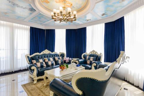 a living room with blue furniture and a chandelier at Lan Rung Beach Resort in Long Hai