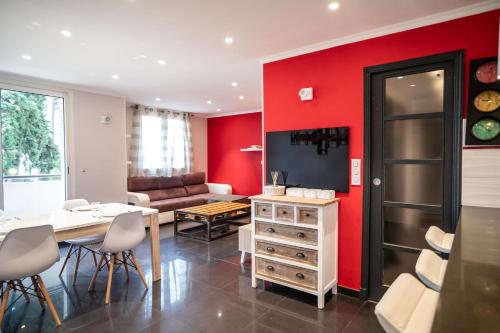 un salon avec des murs rouges et une table et des chaises dans l'établissement GuestReady - Lovely Escape Caucade, à Nice