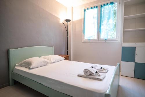 - une chambre avec un lit, des serviettes et une fenêtre dans l'établissement GuestReady - Lovely Escape Caucade, à Nice