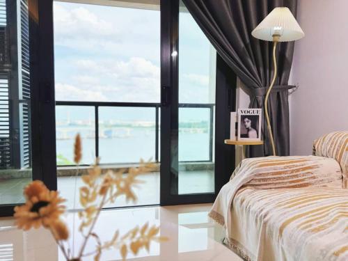 a bedroom with a bed and a large window at TheBess Hotel Tokyo is located adjacent to Singapore and offers a sea viewIt is a family business smart room with the sea view of Princess Bay富力公主湾 in Johor Bahru