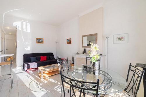 un salon avec une table en verre et un canapé dans l'établissement LE MERVEILLEUX avec 2 chambres, proche de la Croisette, des plages et du Palais, à Cannes