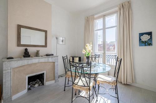 une salle à manger avec une table et une cheminée dans l'établissement LE MERVEILLEUX avec 2 chambres, proche de la Croisette, des plages et du Palais, à Cannes
